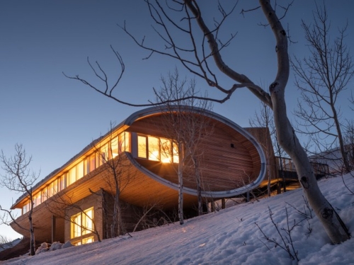 Elip -shaped wooden tube house stands out on white snow